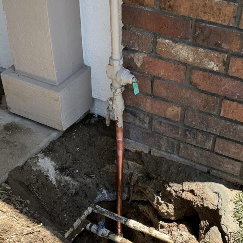Copper water main pipe with valve near house wall Copper water main pipe with valve near house wall
