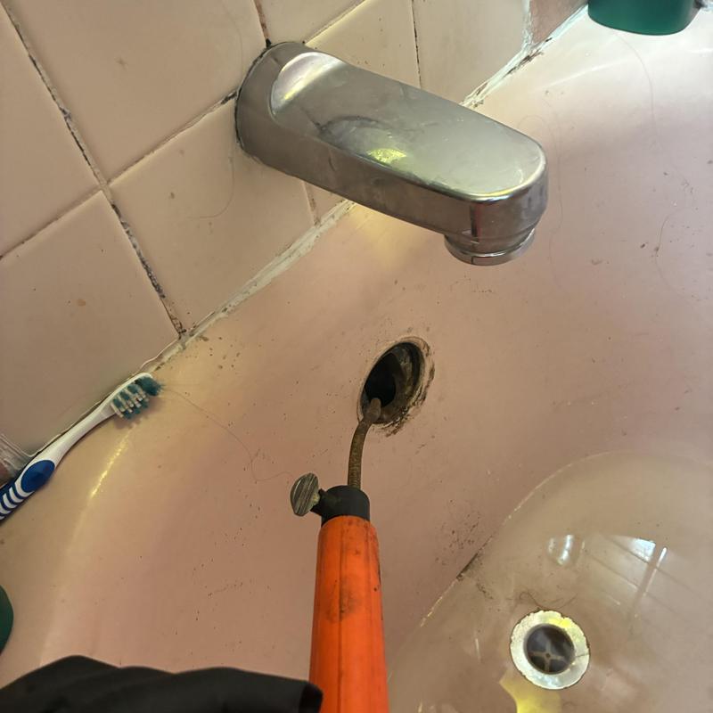 Bathtub drain clog removal with plumbing snake tool