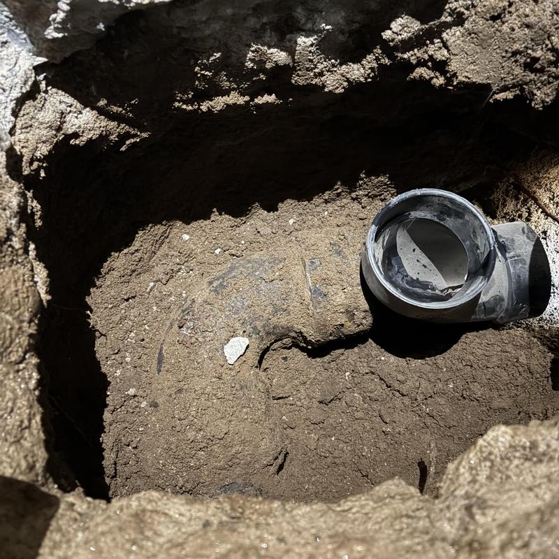Sewer main line excavation with exposed pipe and connector Sewer main line excavation with exposed pipe and connector