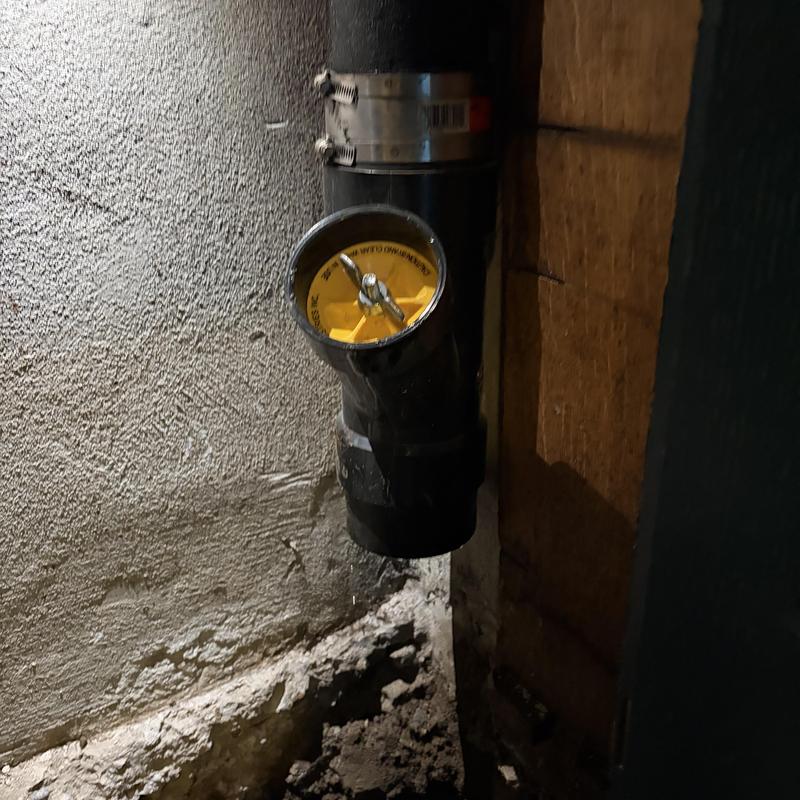 Sewer main line cleanout with test plug in basement wall Sewer main line cleanout with test plug in basement wall