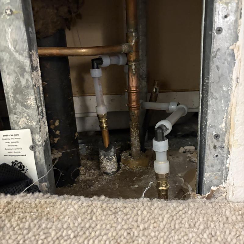 Copper and plastic water pipes in wall cavity