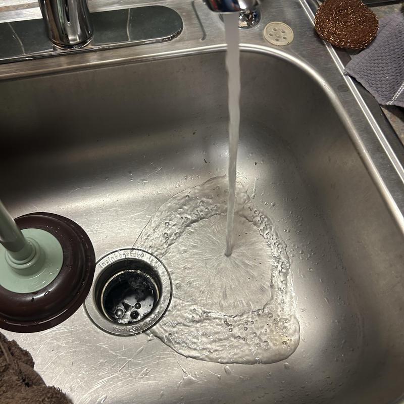 Kitchen sink drain clearing with running water flow Kitchen sink drain clearing with running water flow