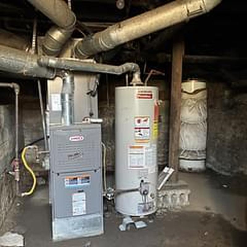 Gas water heater with connected furnace pipes in basement Gas water heater with connected furnace pipes in basement