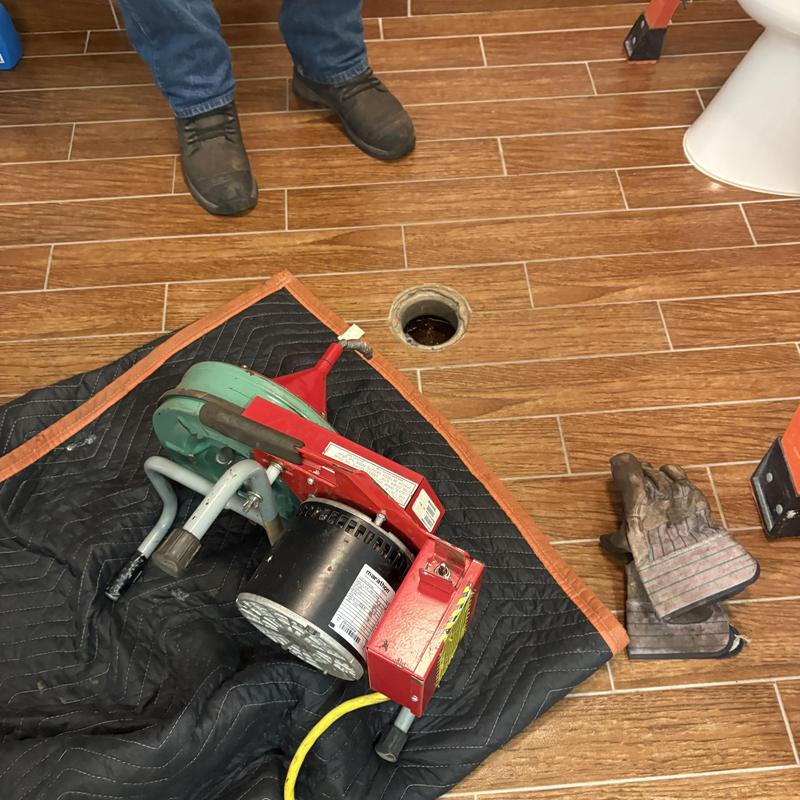 Bathroom drain cleaning machine near open drain hole Bathroom drain cleaning machine near open drain hole
