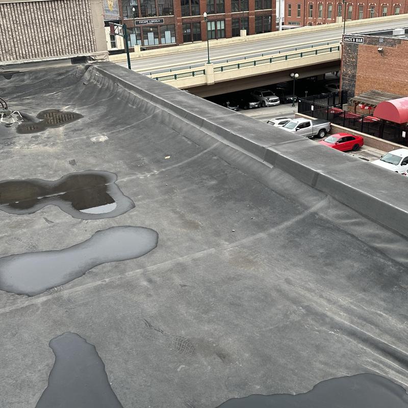 EPDM flat roof with water puddles and curb flashing