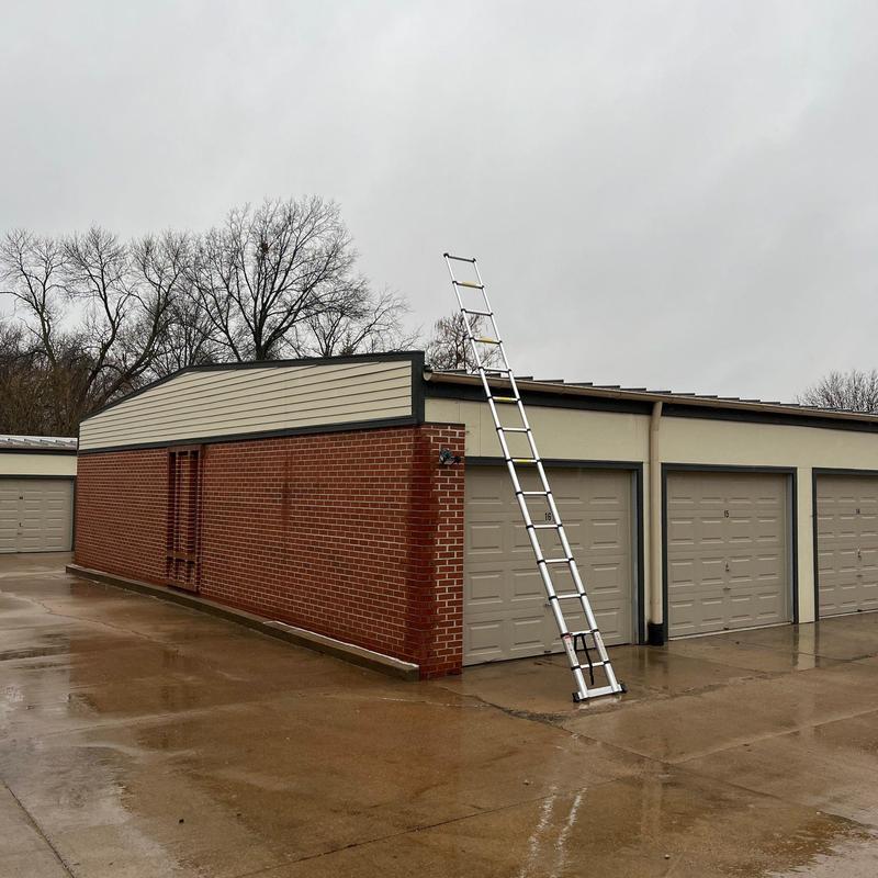 Custom bent ridge caps on garage roof with ladder
