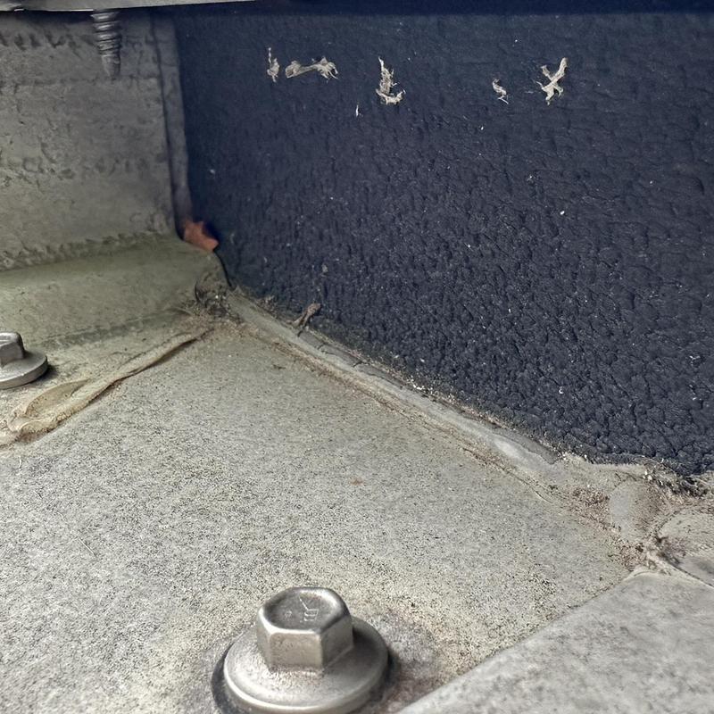 Roof junction with bolts and sealant buildup close-up