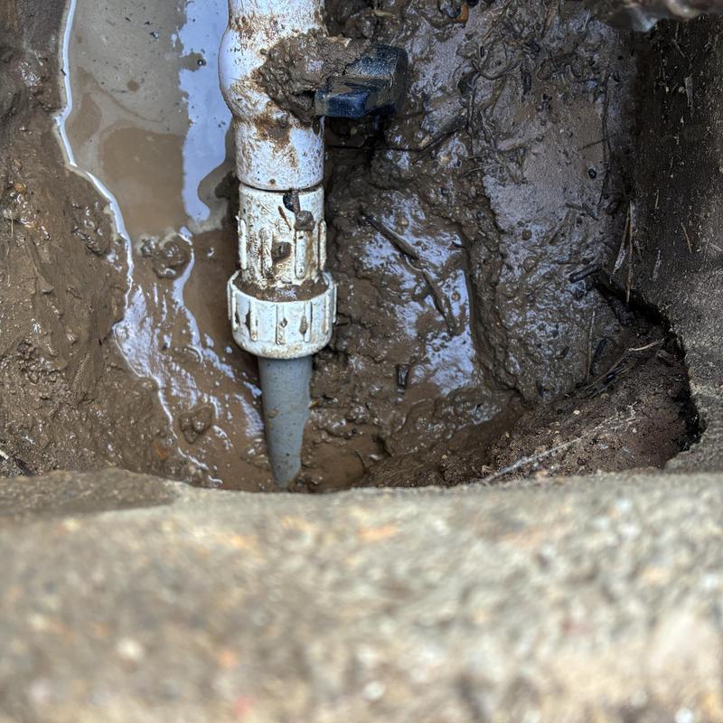 Meter box pipe joint in muddy excavation site