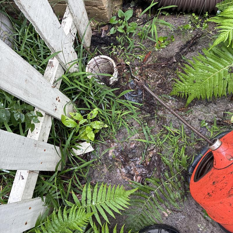 Sewer cleanout with drain snake clearing stoppage outdoors Sewer cleanout with drain snake clearing stoppage outdoors
