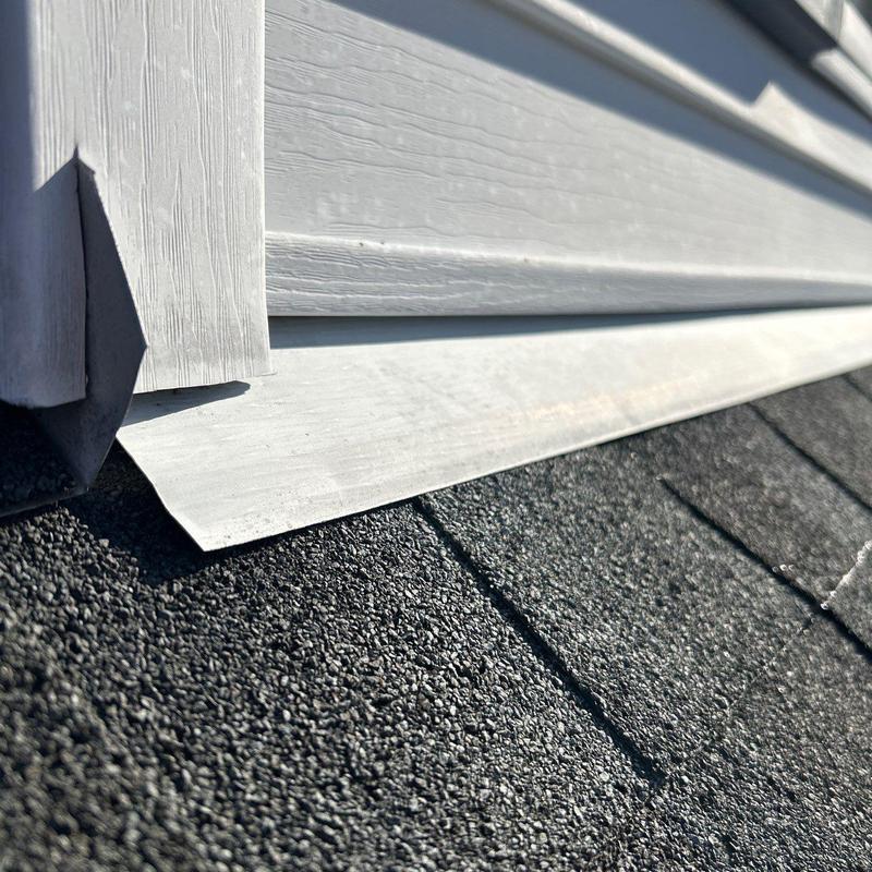 Roof flashing on shingle roof with siding junction