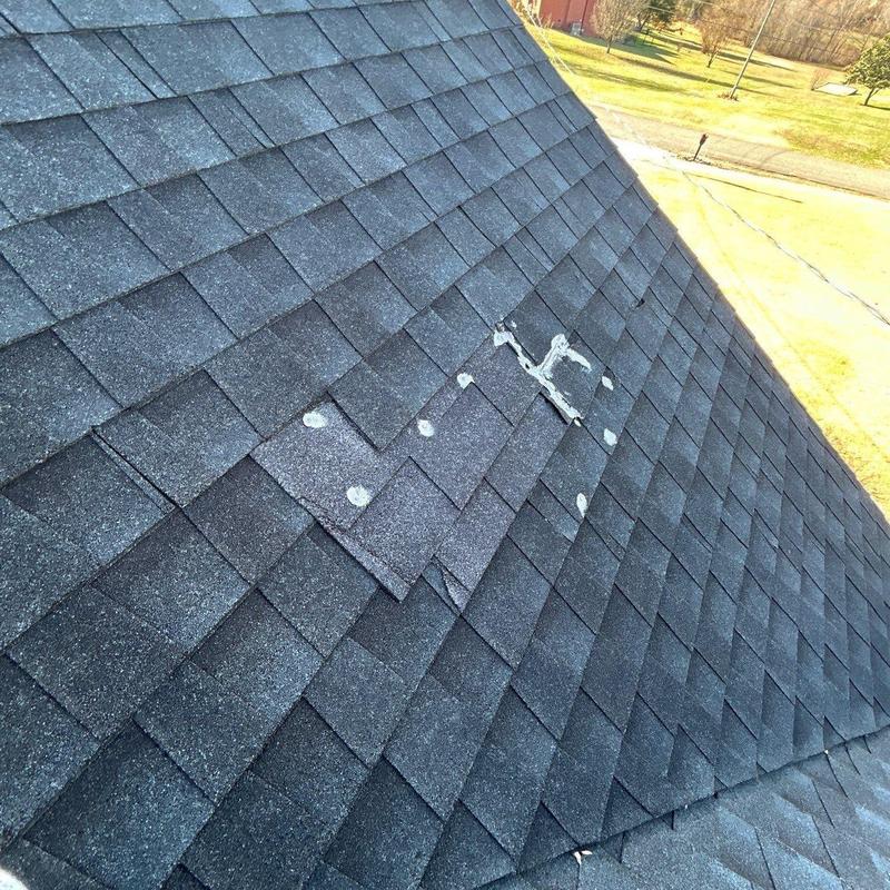 Roof shingles with damaged patch and sealant spots