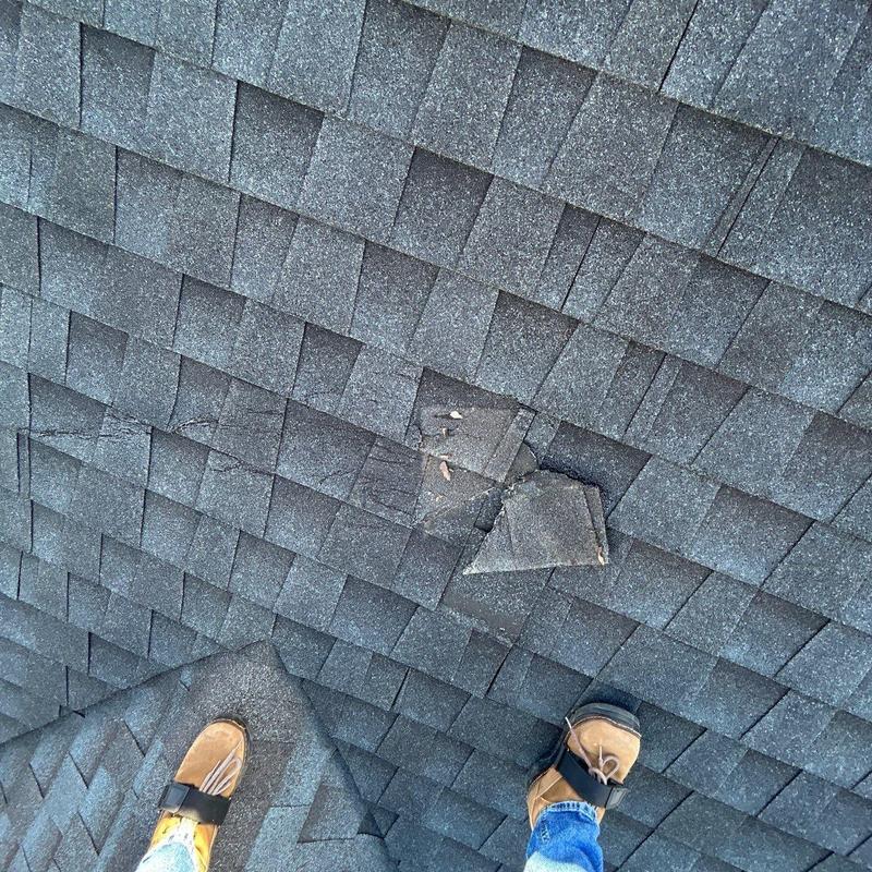 Roof shingles with hail damage and lifted tabs