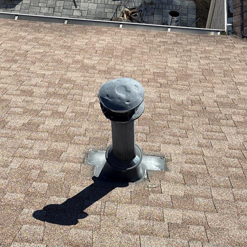 Roof vent pipe with hail damage on asphalt shingles