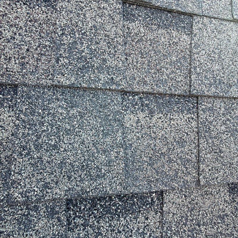 Architectural roof shingles with hail impact damage close-up