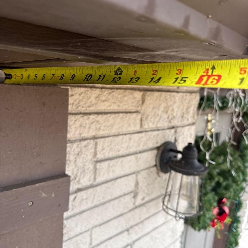 Tape measure under exterior roof overhang measuring clearance
