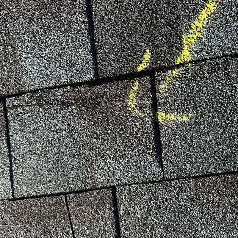 Roof shingles with marked hail damage close-up