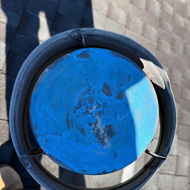 Roof ventilation cap showing hail damage on a shingle roof