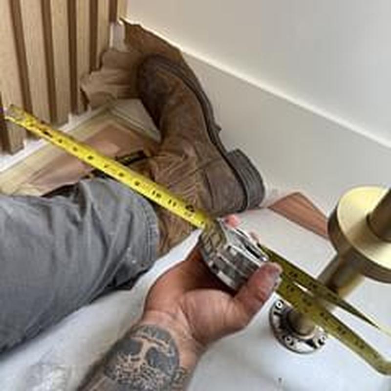 Bathroom tub installation with measuring tape in use