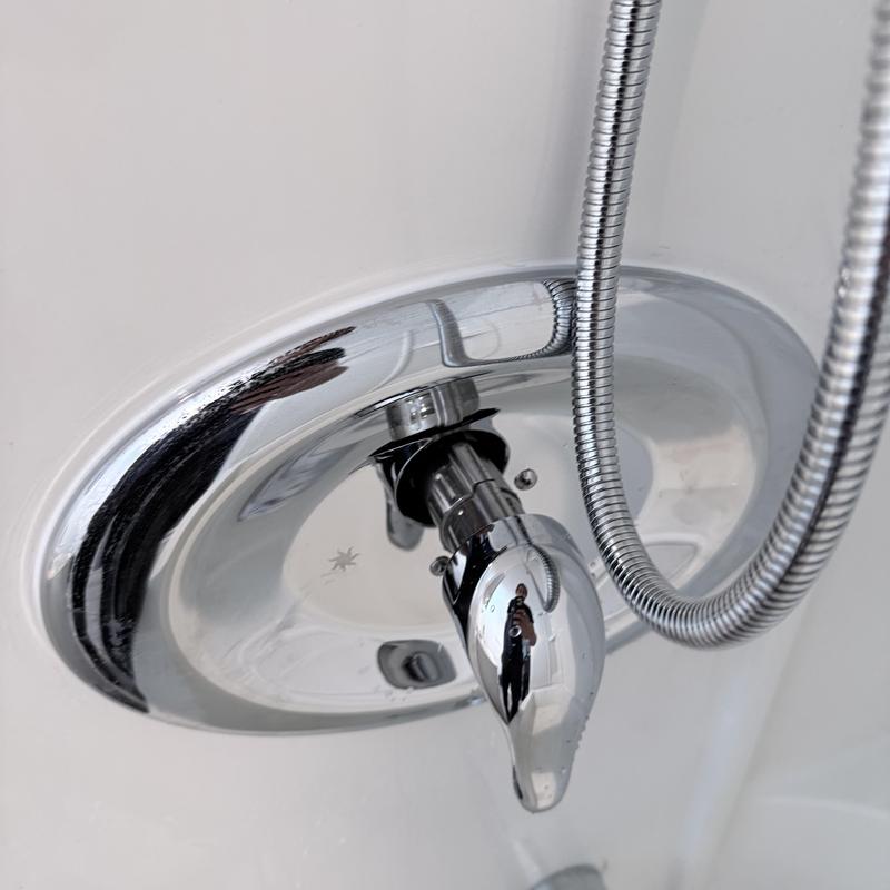 Shower valve with handheld shower hose in white tub