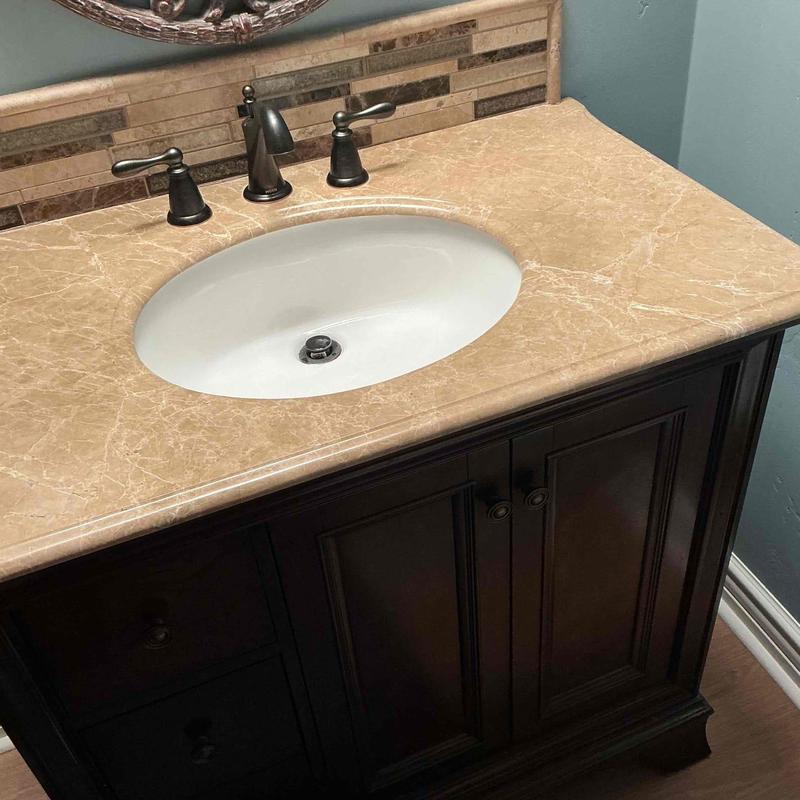 Bathroom sink with mounting brackets and white caulking