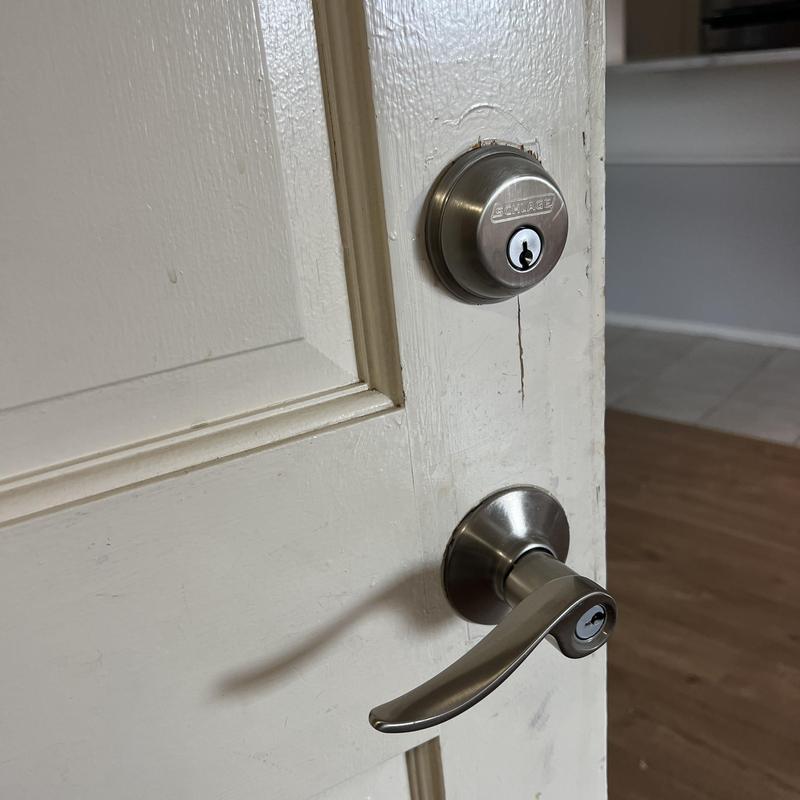Schlage deadbolt and lever door locks on white door