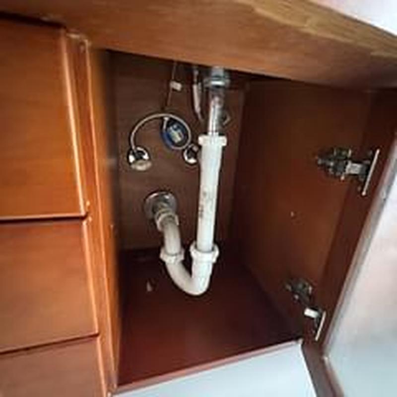 Bathroom sink PVC drain pipe inside cabinet under sink