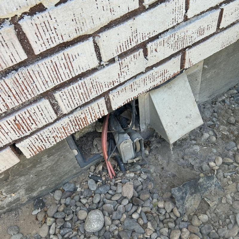 Electrical meter base and wiring near brick foundation Electrical meter base and wiring near brick foundation