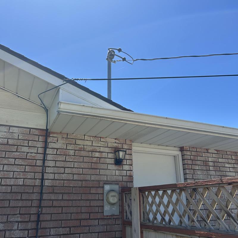 Electric meter and service lines on brick house exterior Electric meter and service lines on brick house exterior