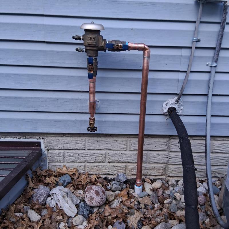 Copper sprinkler tap and valve installation outside house