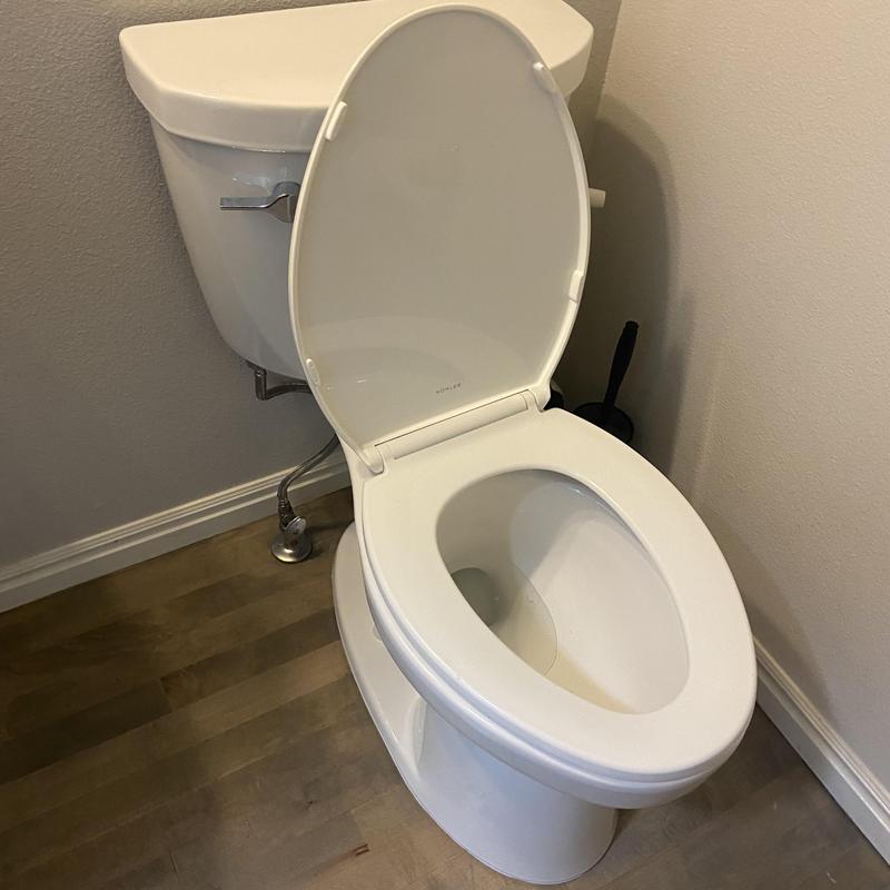 Toilet replacement with open lid in bathroom corner