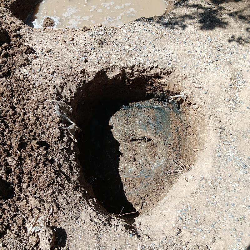 Concrete septic tank riser installation site with soil excavation