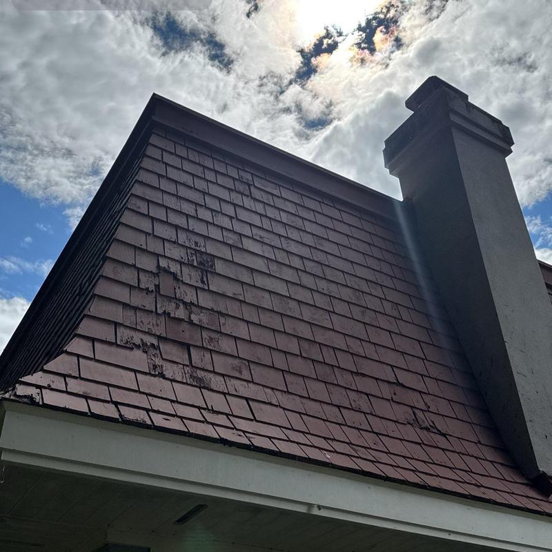 Wood shingle roof with visible wear near chimney