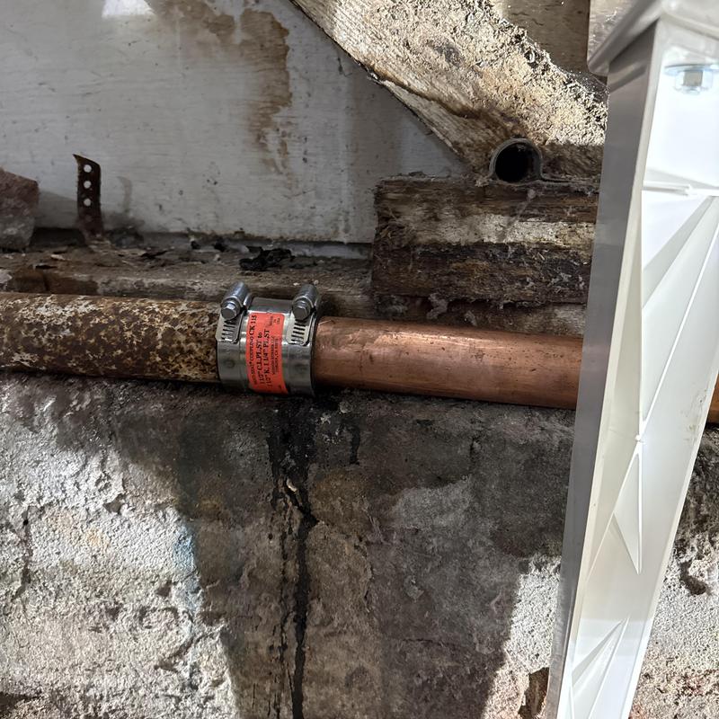 Copper pipe repair with stainless steel clamp installed