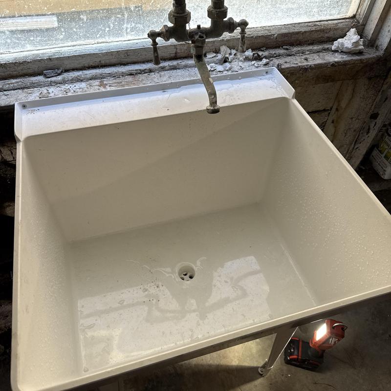 Utility sink with faucet and new drain piping installation