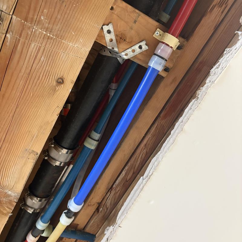 PEX water line with repaired tee fitting in garage ceiling