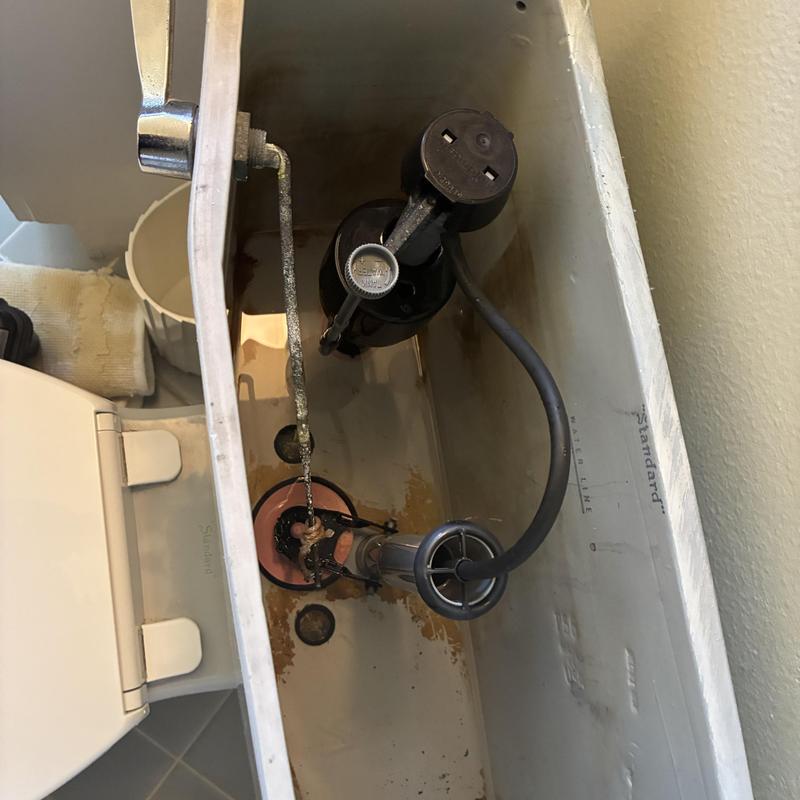 Toilet tank fill valve and flapper assembly inside tank