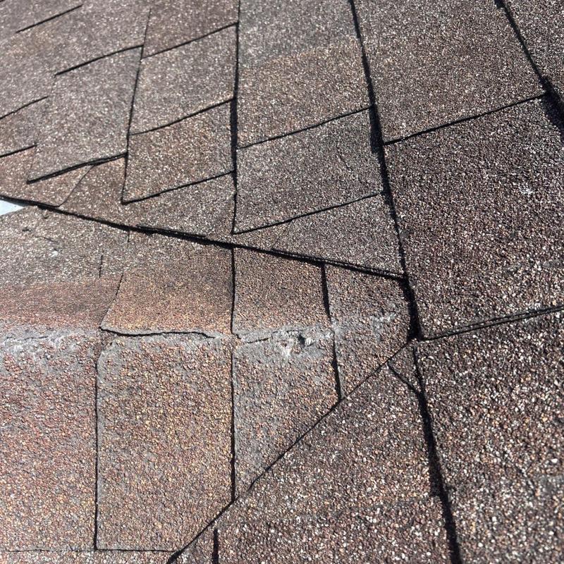 Roof shingles close-up showing cracked and lifted areas