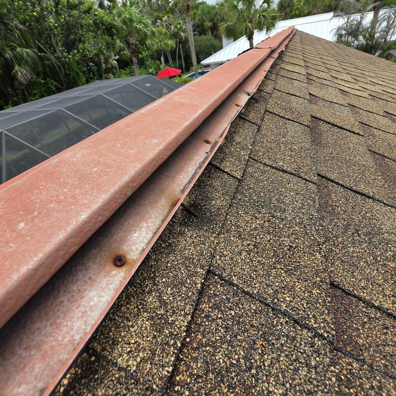 Asphalt shingle roof with damaged ridge vent and fasteners Asphalt shingle roof with damaged ridge vent and fasteners