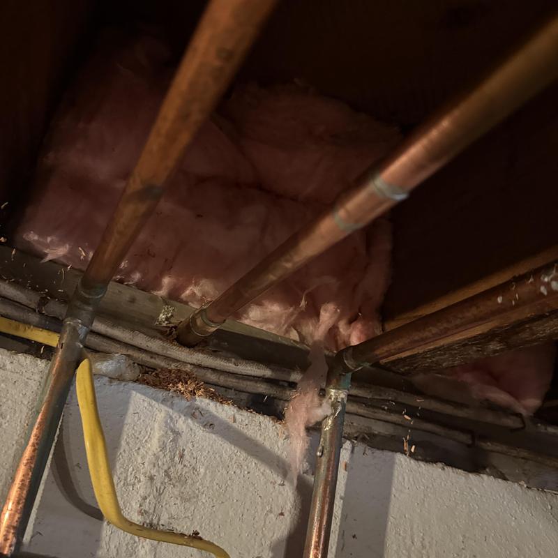 Copper water supply pipes with insulation above basement ceiling