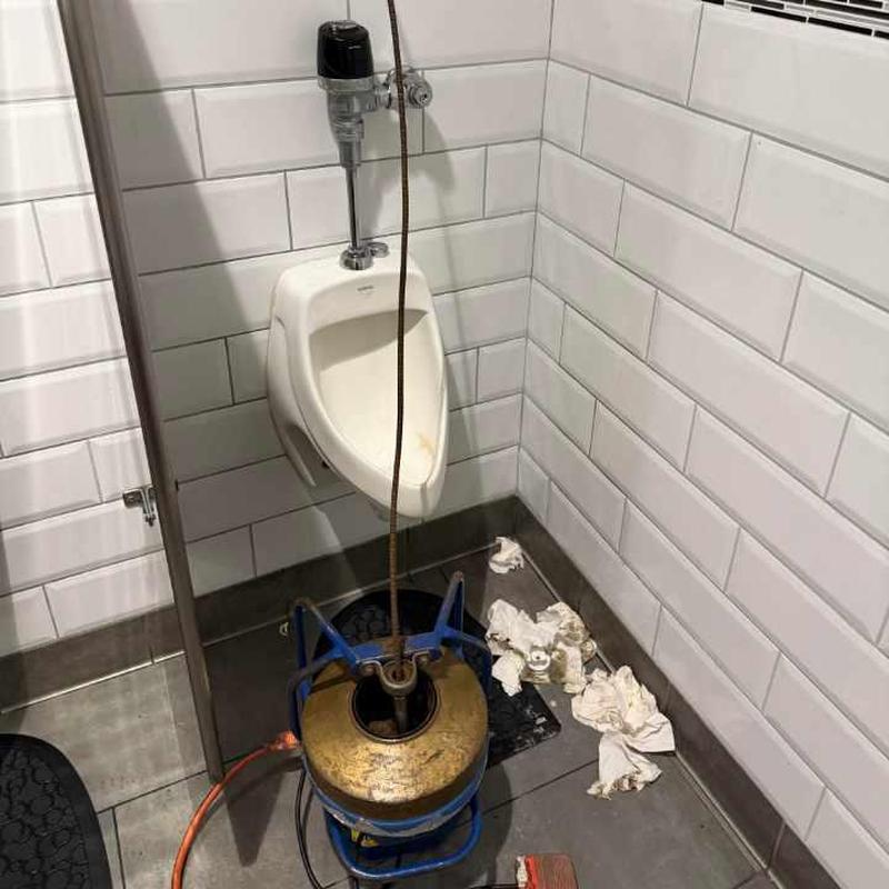 Urinal drain cleaning with drain snake tool