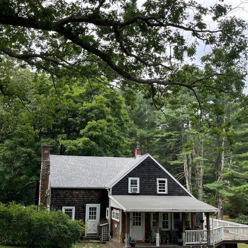 New shingle roof on two-story house in wooded area New shingle roof on two-story house in wooded area