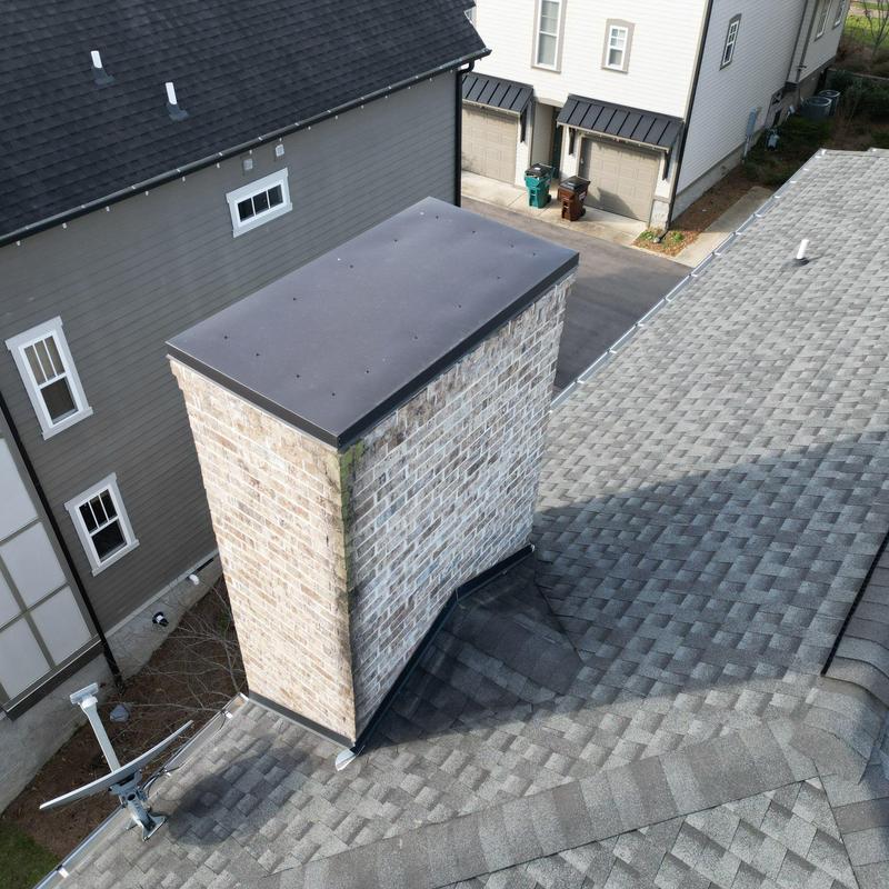 Roof shingles and chimney flashing on residential roof