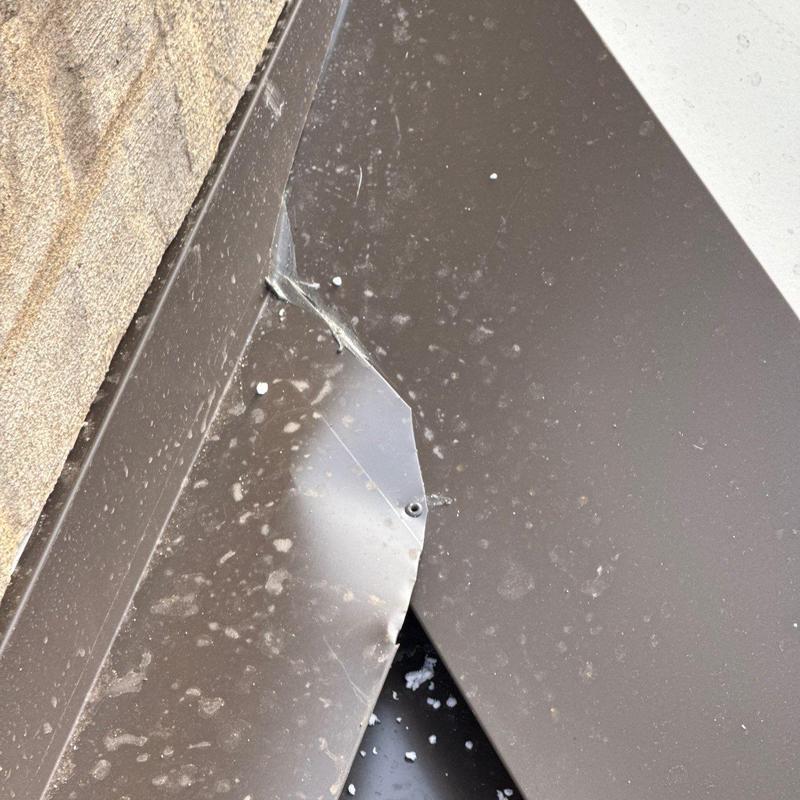Metal roof flashing with hail impact damage