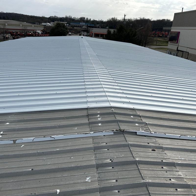 Metal commercial roof with hail damage and repairs