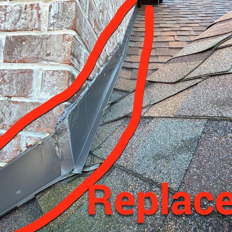 Roof flashing with damage near brick chimney