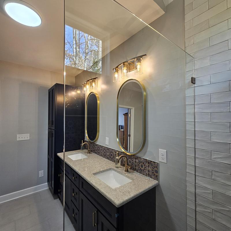 Double bathroom sinks with brass fixtures and arched mirrors Double bathroom sinks with brass fixtures and arched mirrors