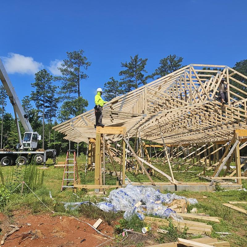 Roof truss framing construction with workers and crane Roof truss framing construction with workers and crane