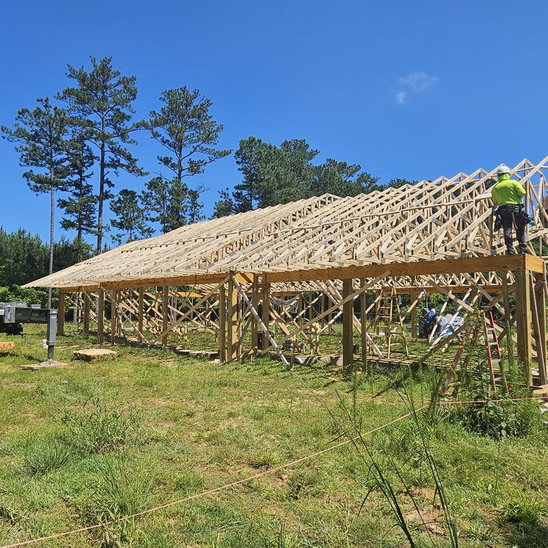 Wooden roof truss framing construction with workers Wooden roof truss framing construction with workers