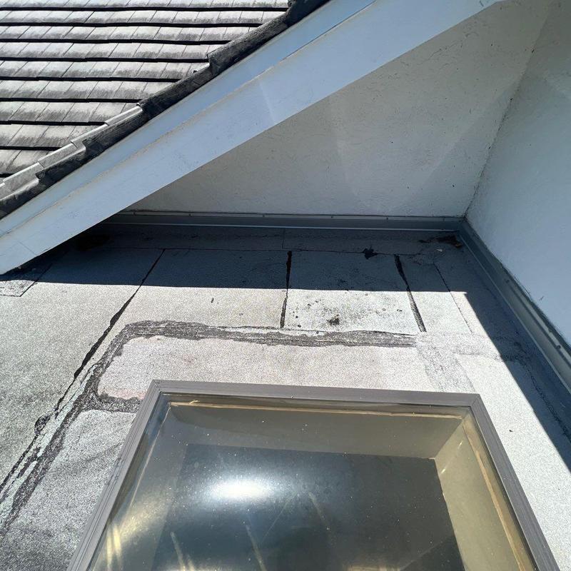 Concrete tile roof and flat roof junction with damage Concrete tile roof and flat roof junction with damage