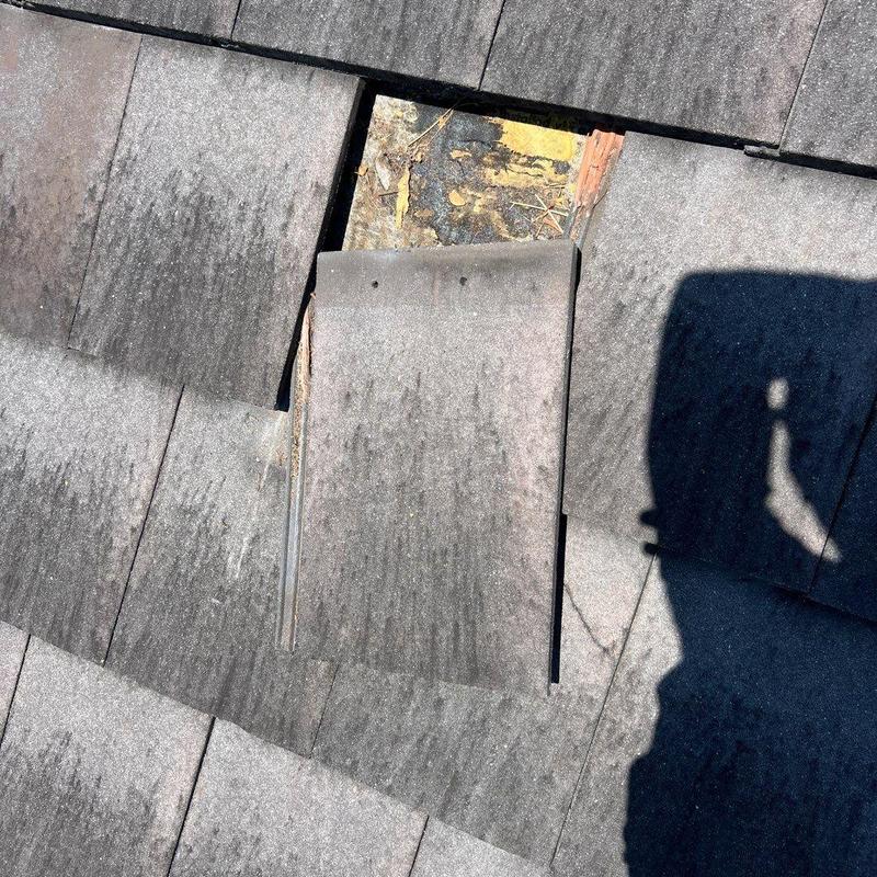 Concrete tile roof with damaged underlayment exposed Concrete tile roof with damaged underlayment exposed